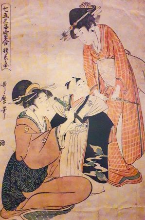 Dwie kobiety ubierające chłopca w jego pierwsze hakama