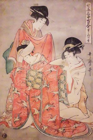 Dwie kobiety ubierające dziewczynkę 